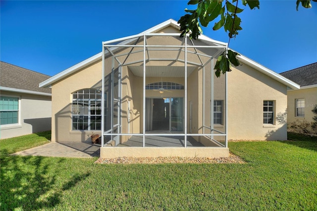 back of property featuring a patio area, a lanai, and a lawn