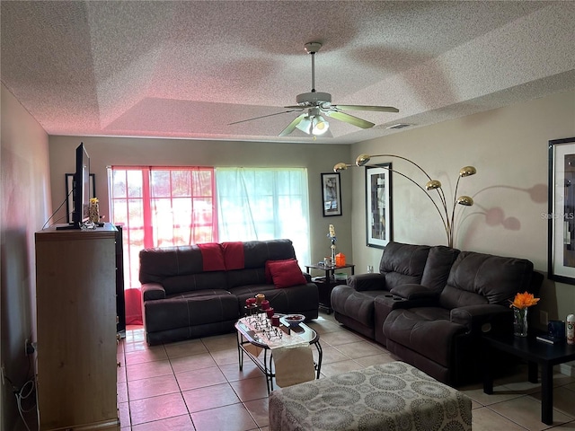 tiled living room featuring ceiling fan, a raised ceiling, and a textured ceiling