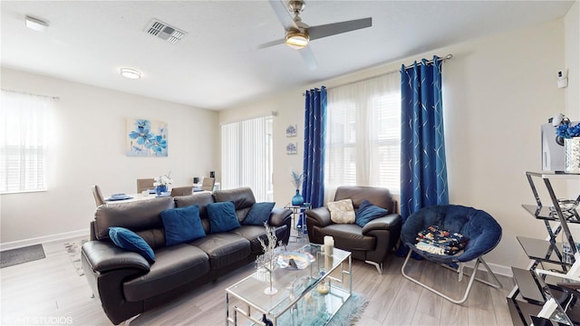 living room featuring ceiling fan and light hardwood / wood-style flooring