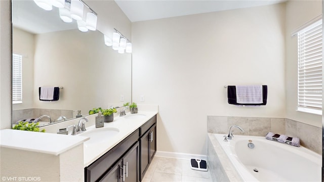 bathroom featuring vanity, tiled tub, plenty of natural light, and tile patterned floors