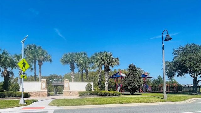 view of property's community featuring a lawn and a playground