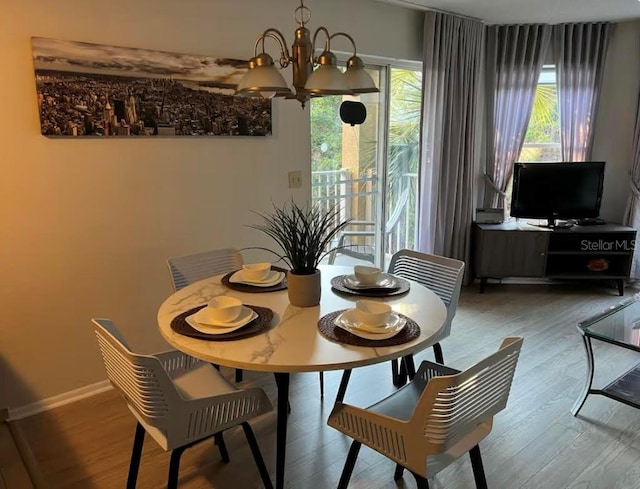 dining area featuring an inviting chandelier and hardwood / wood-style flooring