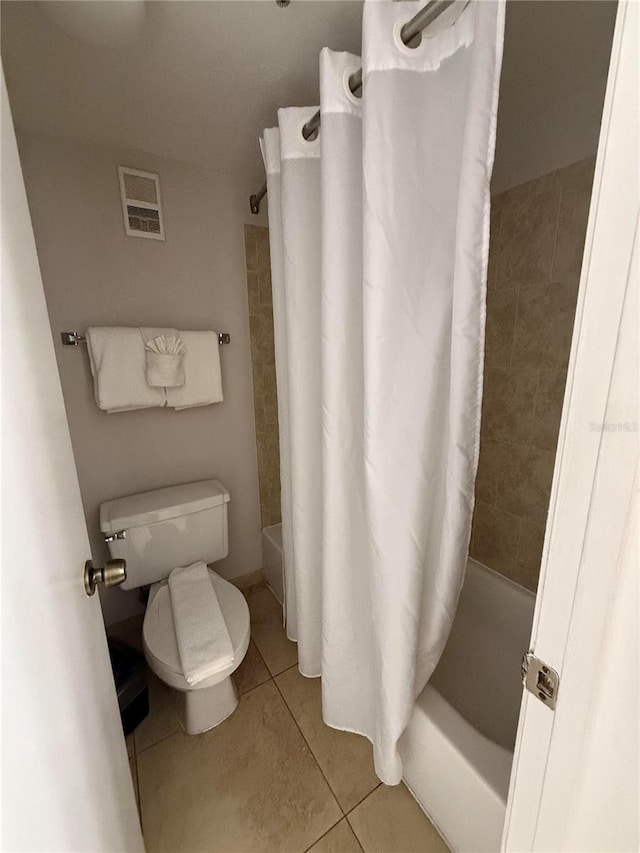 bathroom featuring tile patterned floors, shower / tub combo, and toilet