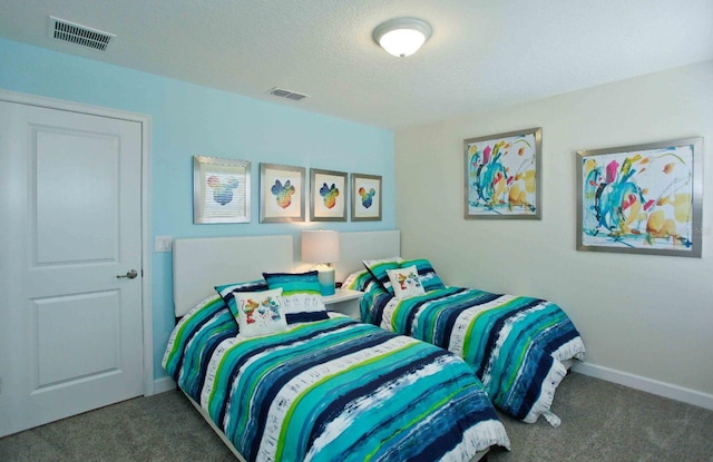 bedroom featuring dark carpet and a textured ceiling