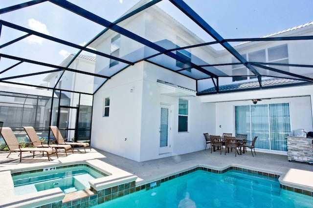 exterior space with an in ground hot tub, a patio area, and a lanai