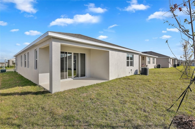 rear view of property featuring central AC, a yard, and a patio area