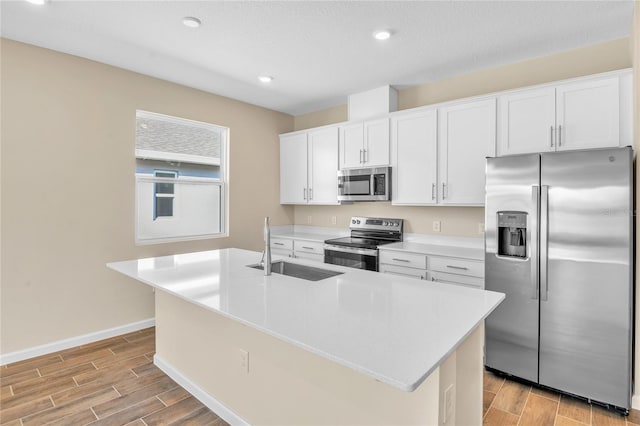 kitchen with white cabinetry, sink, stainless steel appliances, a center island with sink, and a textured ceiling