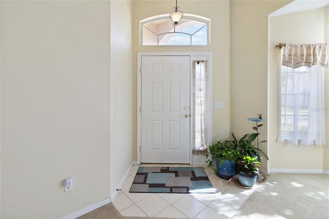 entrance foyer with a towering ceiling and carpet floors