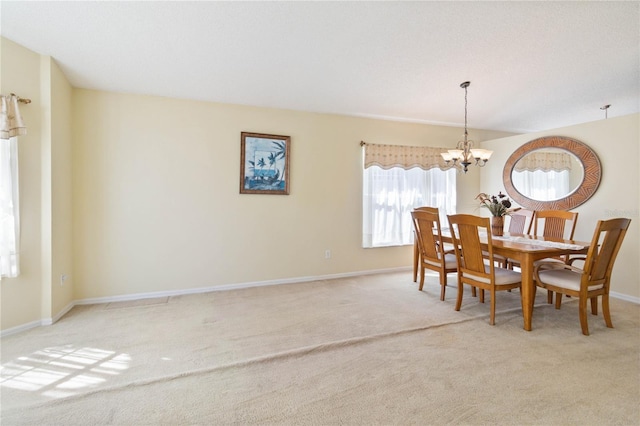 carpeted dining area featuring a chandelier