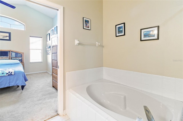 bathroom featuring a relaxing tiled tub, vaulted ceiling, and a wealth of natural light