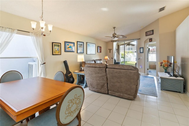 tiled dining area featuring lofted ceiling and ceiling fan with notable chandelier