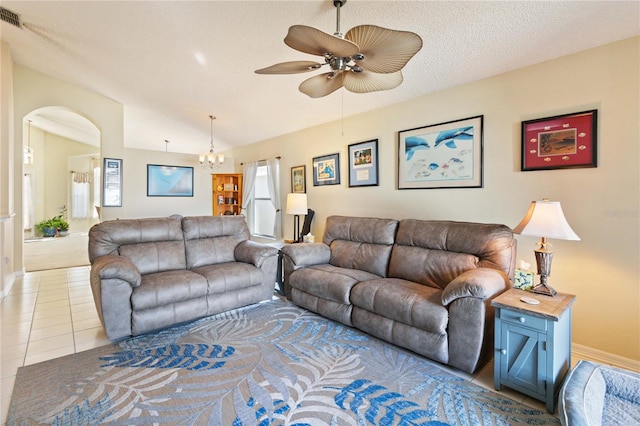 tiled living room with a textured ceiling, ceiling fan with notable chandelier, and vaulted ceiling