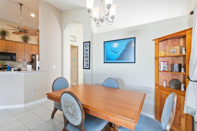 dining space featuring lofted ceiling, a textured ceiling, ceiling fan with notable chandelier, and light tile patterned floors