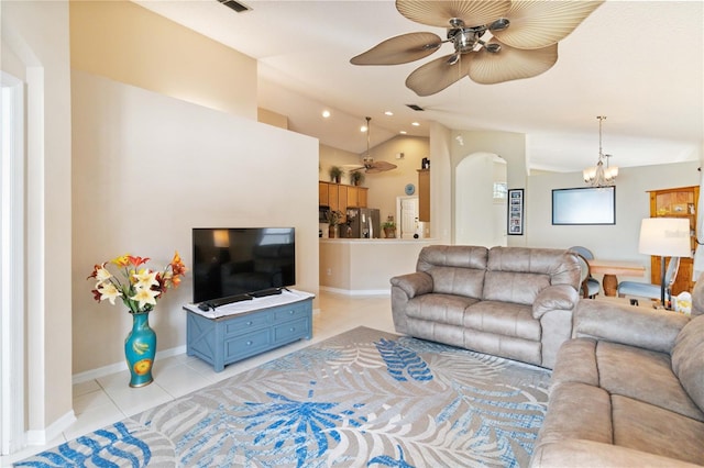 tiled living room featuring vaulted ceiling and ceiling fan with notable chandelier