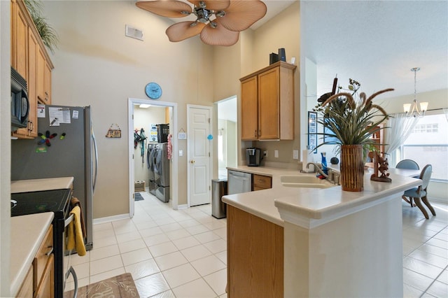 kitchen featuring range with electric cooktop, sink, light tile patterned flooring, and washing machine and clothes dryer