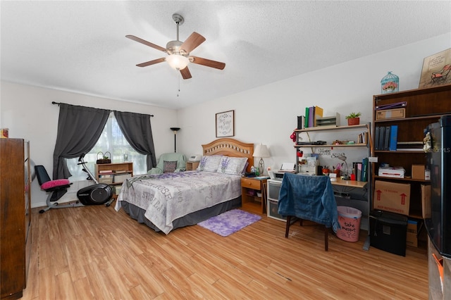 bedroom with light hardwood / wood-style floors, a textured ceiling, and ceiling fan