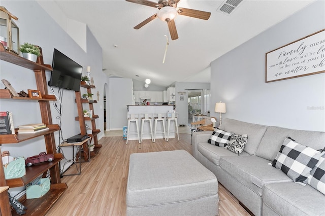 living room with lofted ceiling, light wood-type flooring, and ceiling fan