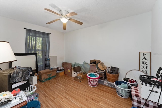 interior space with a textured ceiling, light wood-type flooring, and ceiling fan