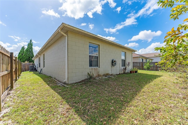 rear view of house with a yard and central AC