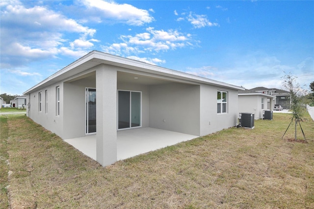 back of property with central AC unit, a yard, and a patio