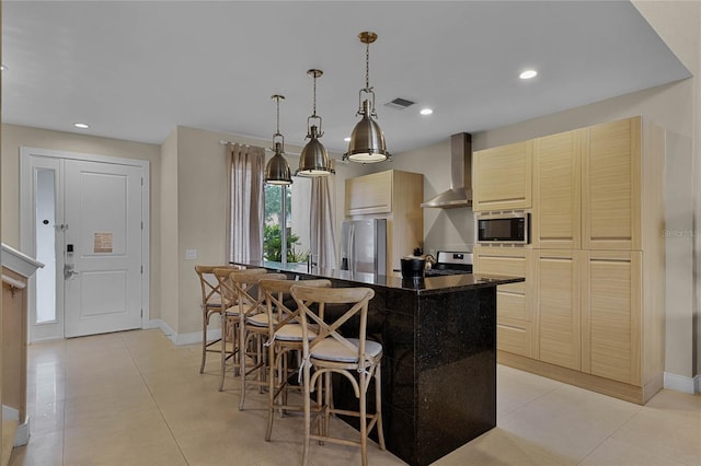 kitchen featuring hanging light fixtures, a kitchen breakfast bar, stainless steel appliances, wall chimney exhaust hood, and a center island