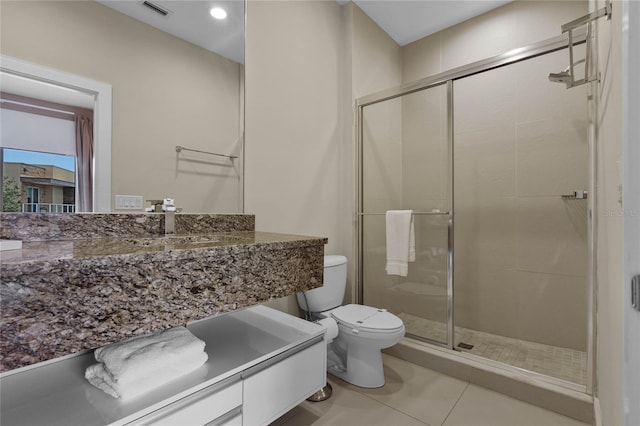 bathroom with vanity, toilet, tile patterned floors, and a shower with door