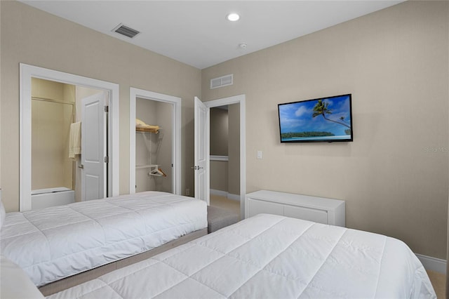 bedroom with a walk in closet, a closet, and carpet floors