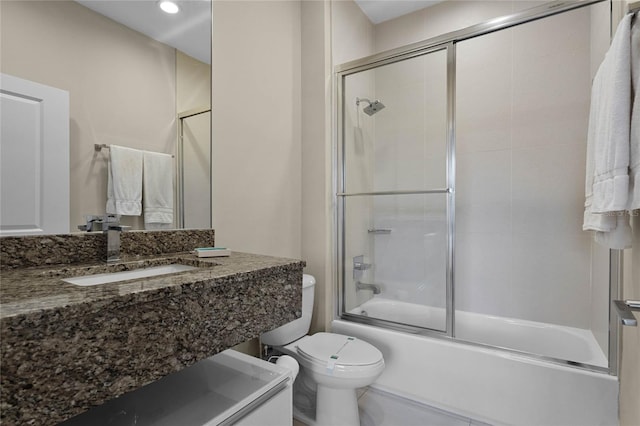 full bathroom featuring toilet, vanity, and shower / bath combination with glass door