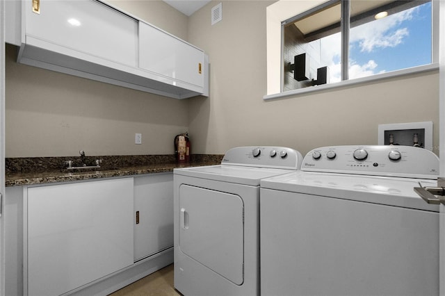 laundry area featuring cabinets, sink, and separate washer and dryer