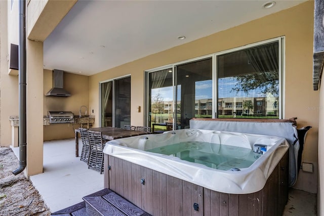 view of patio / terrace with a hot tub, grilling area, and sink