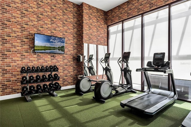 exercise room featuring brick wall