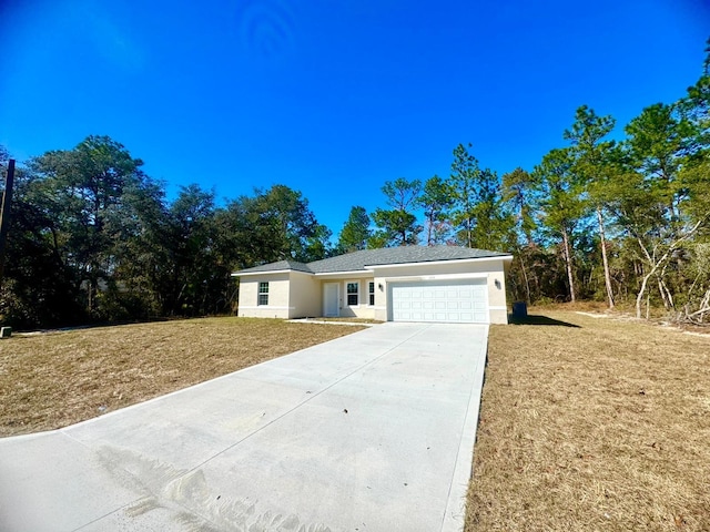 ranch-style house featuring a garage and a front lawn