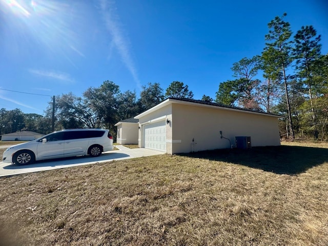 view of home's exterior featuring a garage, a yard, and central air condition unit