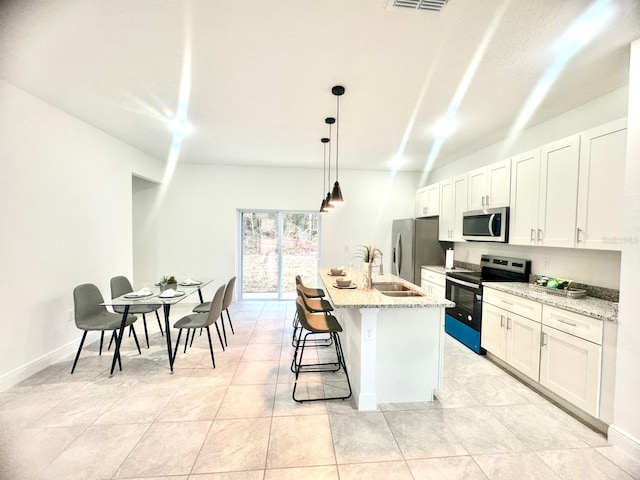 kitchen with stainless steel appliances, white cabinetry, a kitchen island with sink, and pendant lighting