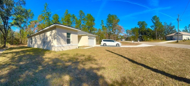 view of home's exterior with a garage and a lawn