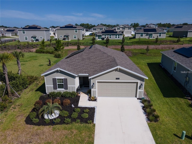 view of front facade featuring a residential view, a garage, concrete driveway, and a front yard