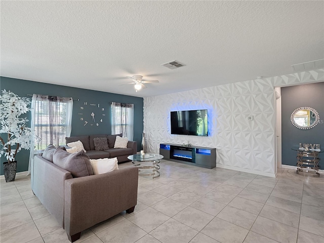 living room with a textured ceiling, light tile patterned floors, and ceiling fan