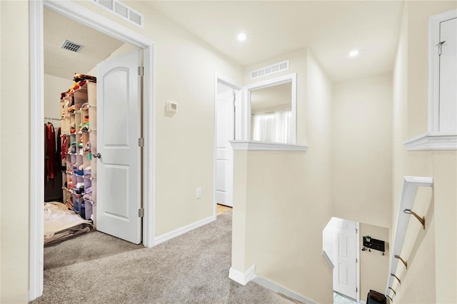 corridor featuring light colored carpet