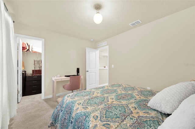 carpeted bedroom featuring a spacious closet and a closet