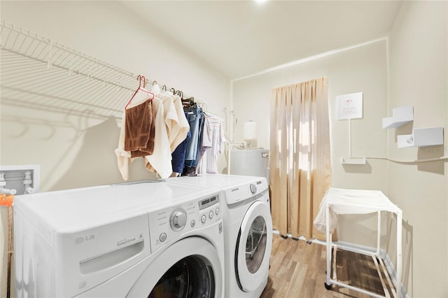 laundry area with light hardwood / wood-style flooring and washer and clothes dryer