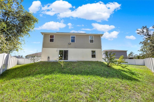 rear view of property featuring a yard