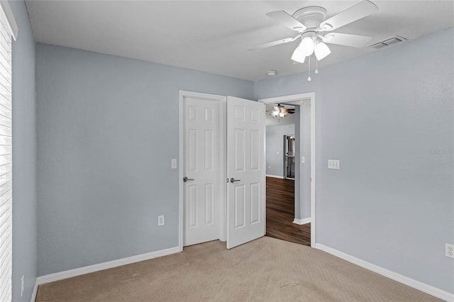 unfurnished bedroom with light carpet and ceiling fan