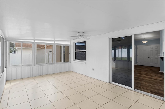 unfurnished sunroom featuring ceiling fan