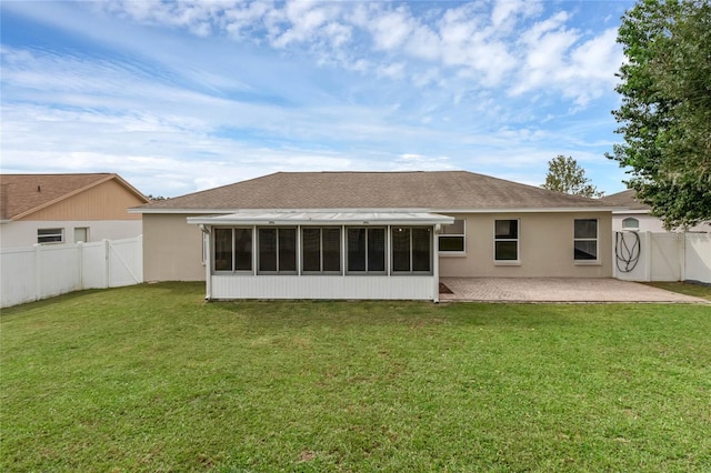 rear view of property with a patio, a sunroom, and a lawn