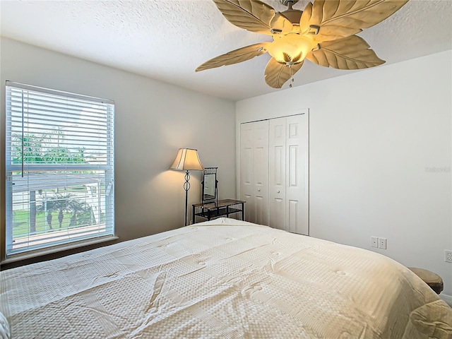 bedroom featuring a textured ceiling, ceiling fan, and a closet