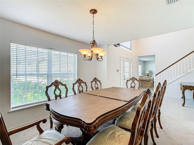 dining area with a healthy amount of sunlight, light tile patterned floors, and a notable chandelier