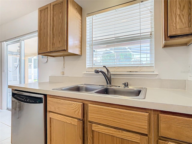 kitchen featuring dishwasher, sink, and light tile patterned flooring