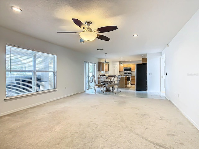 unfurnished living room with light carpet and ceiling fan