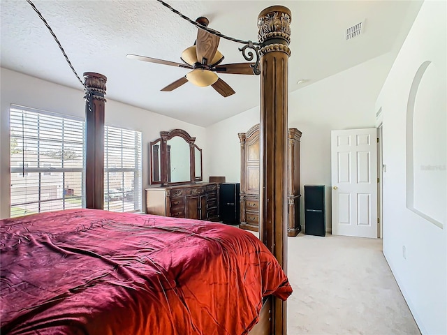 carpeted bedroom featuring a textured ceiling, vaulted ceiling, and ceiling fan