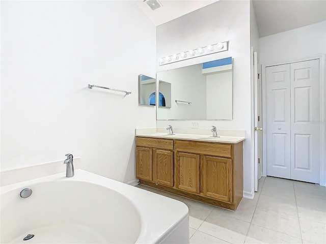 bathroom with vanity, a bath, and tile patterned floors